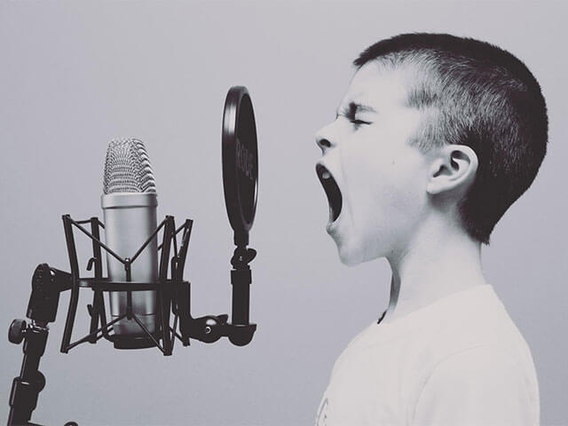 A kid shouting into a microphone