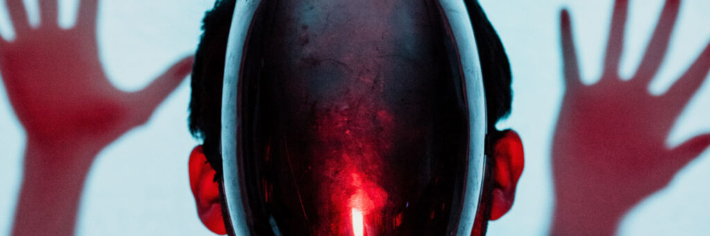 A humanoid form with a glowing red glass face