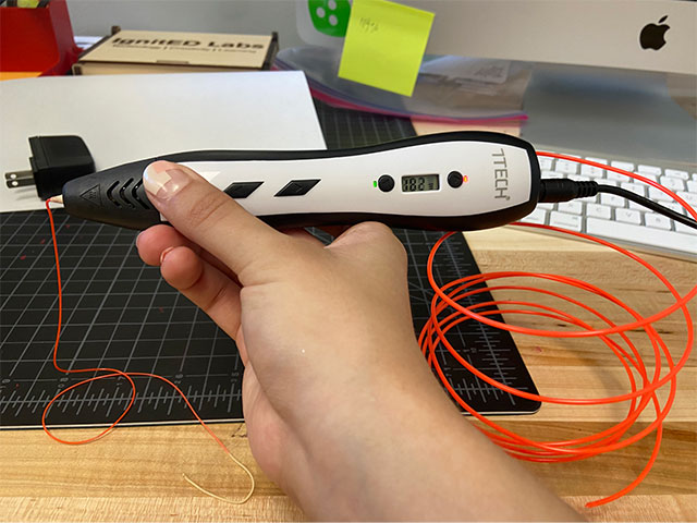 Holding the 3D pen as material starts to extrude